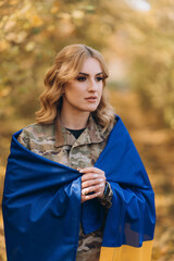 Fototapeta premium A Ukrainian military woman with a Ukrainian flag.