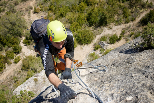 A man climbing a ferrata route in Calcena, Spanish mountains.