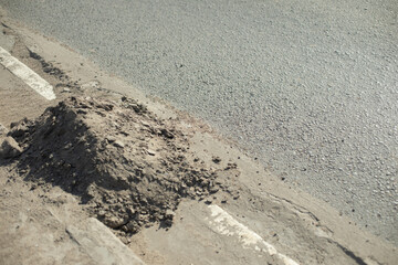 Dirt on road. Dust on side of road. Cleaning details. Lot of dirt.