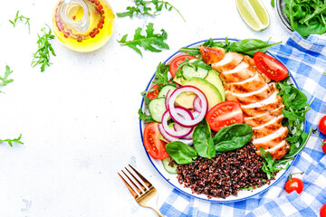 Grilled chicken meat, red quinoa healthy salad  with tomatoes, avocado, arugula and spinach. Detox, ketogenic diet food. White table background, top view