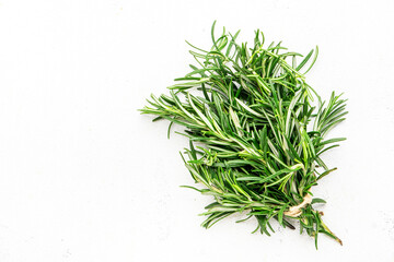 Fresh rosemary bunch and jute rope on white stone table background. Spicy herb for cooking  Top view