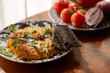 Omelette, scramble, ostrich egg shakshuka, with vegetables and salad, and homemade bread. Farm organic food. Cooking food. Soft selective focus.