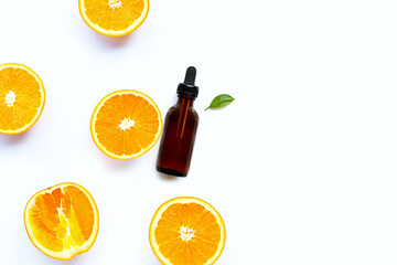 Essential oil with fresh orange fruit on white background.