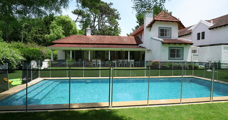 House exterior during sunny day. Residential home with swimming pool