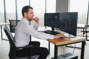 Serious business man trader analyst looking at computer monitor, investor broker analyzing indexes,...