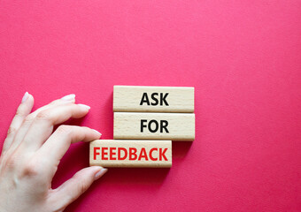Feedback symbol. Concept word Ask for feedback on wooden blocks. Businessman hand. Beautiful red background. Business and Ask for feedback concept. Copy space