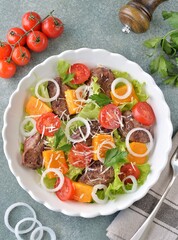 Salad with chicken liver, pumpkin, cherry tomatoes, onions, lettuce and parmesan
