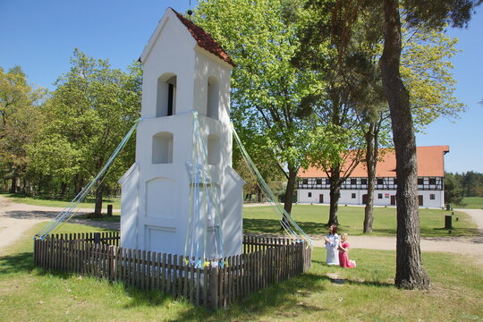 Modląca się mama z dzieckiem przed kapliczką. Olsztynek. Muzeum Budownictwa Ludowego. Polska - Mazury - Warmia.