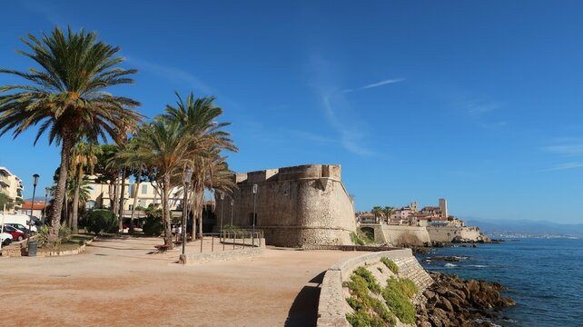 Tour du bastion Saint-André à Antibes, square Albert 1er avec des palmiers et vue sur le château Grimaldi et les remparts de la vieille ville sur la côte d’azur au bord de la mer Méditerranée (France)