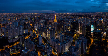 Aerial view of an antenna, surrounded by buildings at dusk in the city of São Paulo