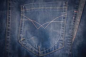 Blue jeans pocket as a background. Close-up of a denim empty back pocket.