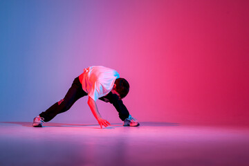 guy hiphop performer break dance in neon club lighting and doing acrobatic trick, male dancer...