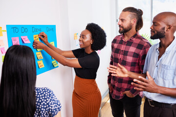 Scrum team participates in daily stand up on KANBAN board, mobile app developers