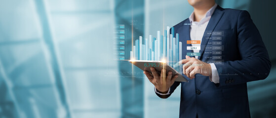 Businessman using tablet to calculate financial figures and analyze growth Stock Market and Digital Markets and Business Strategy, Banking and Finance, Business Investing in the Global Economy.