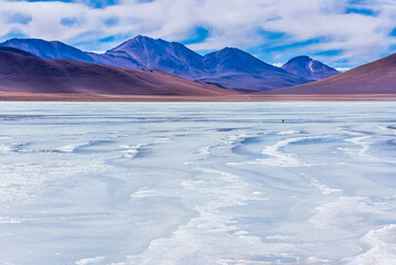 Landscape of frozen lake surrounded by mountains in the bolivian plateau