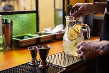 Fototapeta na wymiar bartender preparando una jarra de limonada o gin tonic
