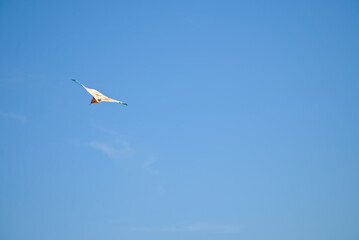A colourful kite on a clear blue sky on a sunny day
