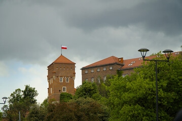 Rooftops and the Polish flag on the Wawel castle in Kraków, Poland on a cloudy day