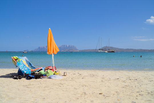 A sunbed and an umbrella by the sea on the Pellicano beach in Pittulongu, Italy