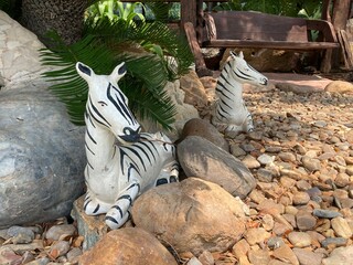 ceramic zebras toy on the pebbles in the garden