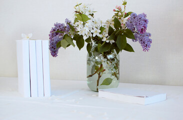 bouquet of flowers in vase and books on table at home. The concept of reading, relaxation. summer season