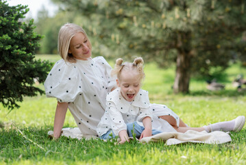 Woman with disabled girl in the summer park. Child cerebral palsy. Disability.Means of rehabilitation. Family with disabled kid.