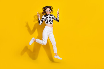 Full length photo of cheerful cool girl wear cow skin shirt dark glasses v-signs empty space isolated yellow color background