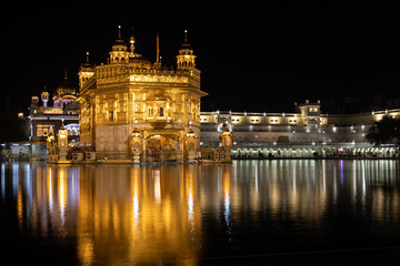 Golden temple in Amritsar at night with a reflection in the pond