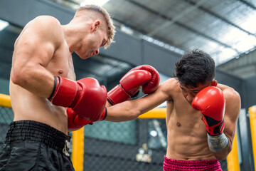 Fototapeta na wymiar Two boxers Caucasian and Filipino boxers are fighting on professional boxing ring .It is a sport that trains endurance and physical strength.