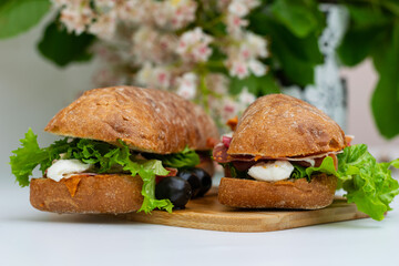 Fresh panino spread with cheese, mozzarella, ham, olives and salad