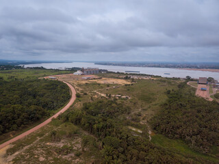 Aerial drone view of agriculture silos for storing soybeans and Tapajos river, Itaituba, Para, Brazil. Concept of environment, nature, ecology, climate change, deforestation, climate change, industry.