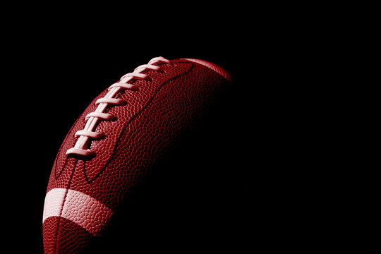 Red American football ball close up on black background. Horizontal sport theme poster, greeting cards, headers, website and app