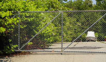 Chain link fence with barbed wire: a symbol of confinement, security, restriction, and the divide between safety and danger