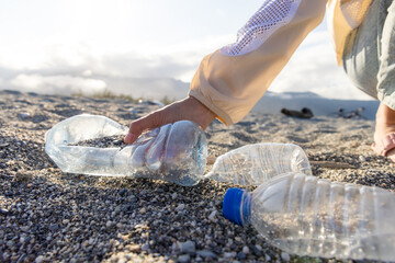 Volunteer pick plastic bottle trash at beach