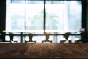 Empty wooden table in front of abstract blurred background of coffee shop . can be used for display Mock up  of product