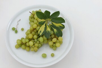 Green grapes, bunch on a white plate, leaf, branch, fresh fruit, summer, background, background...