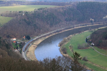 Personenzug fährt an der Elbe an Bad Schandau vorbei
