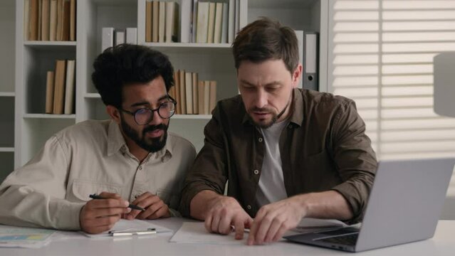 Multiethnic businessmen problem solving team work with laptop in home office diverse Arabian Indian Caucasian men colleagues talk business discussion disappointed breakdown difficult paperwork trouble