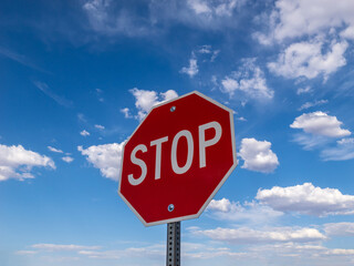 Stop sign and blue sky with clouds