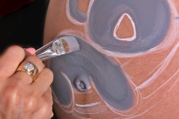 hand painting pregnant belly. Baby shower and bellypainting
