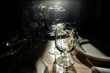 empty crystal goblets against the light on a set table