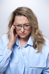 Adult woman in glasses with a headache, on a white background