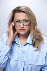 Adult woman in glasses with a headache, on a white background