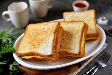 Sandwiches with egg, ham and toast cheese fried in a pan