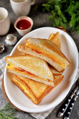 Sandwiches with egg, ham and toast cheese fried in a pan