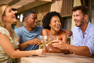 Group Of Smiling Multi-Cultural Friends Outdoors At Home Drinking Wine Together