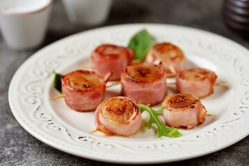 Sea scallops fried in bacon on a skewer.