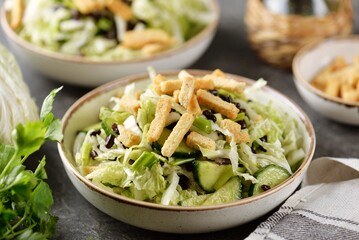 Healthy Chinese cabbage salad with cucumbers, green onions, black beans and croutons.