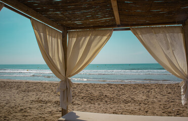 Fototapeta na wymiar Canopied lounge chair. White beach canopies.