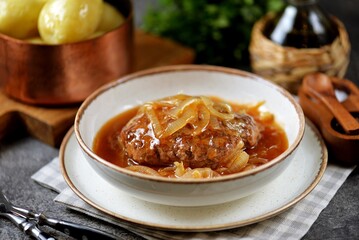 Beef cutlet in tomato sauce with onions.